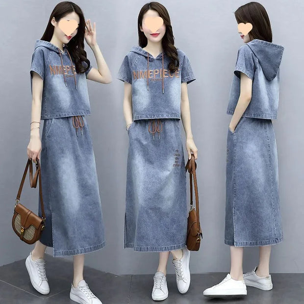 Denim outfit with hood and long skirt worn by a model on a gray background