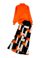 Orange sweater and black and white patterned pants on a white background