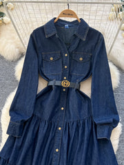 Denim dress on a hanger with a white textured background