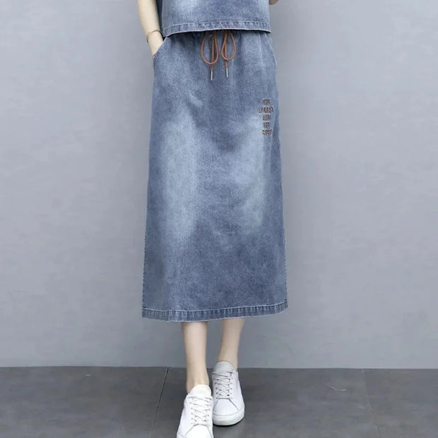 Denim skirt worn by a mannequin on a gray background