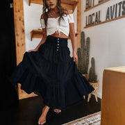 Woman wearing a white top and black skirt in a room with wooden walls and cacti.