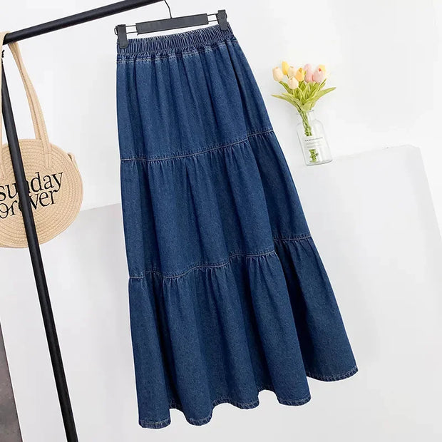 Blue denim skirt on a hanger against a white background