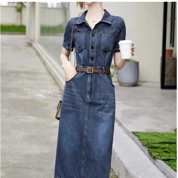 Woman wearing a denim dress holding a coffee cup outdoors.