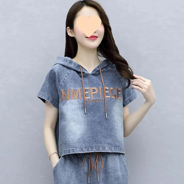 Person wearing a denim hoodie with 'NIMEPIECE' branding on a gray background