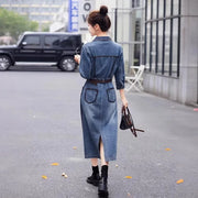 Woman wearing a denim dress walking on a street.