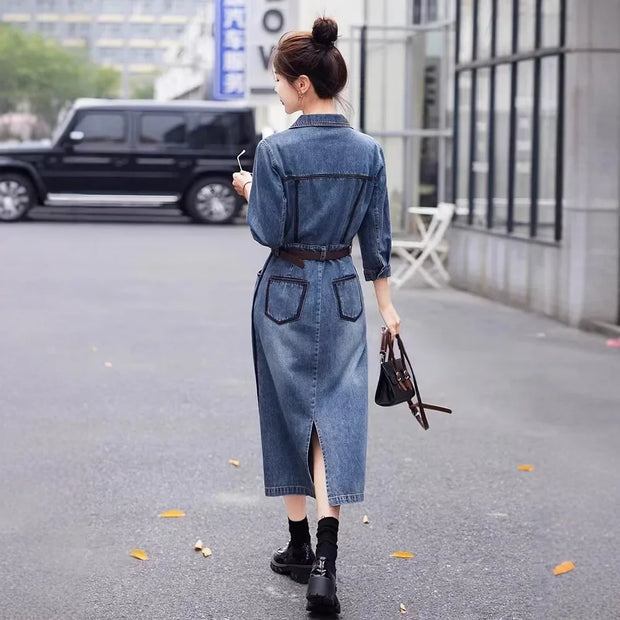 Woman wearing a denim dress walking on a street.