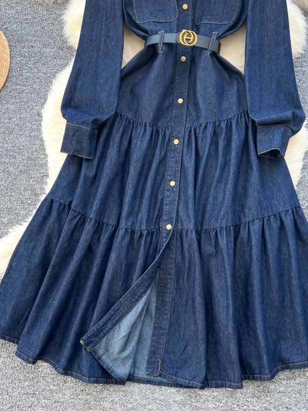 Blue denim dress with a belt on a textured surface