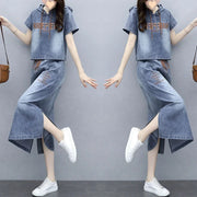 Denim outfit with matching top and pants worn by a person on a gray background