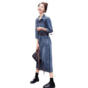Woman wearing a denim dress holding an umbrella on a white background