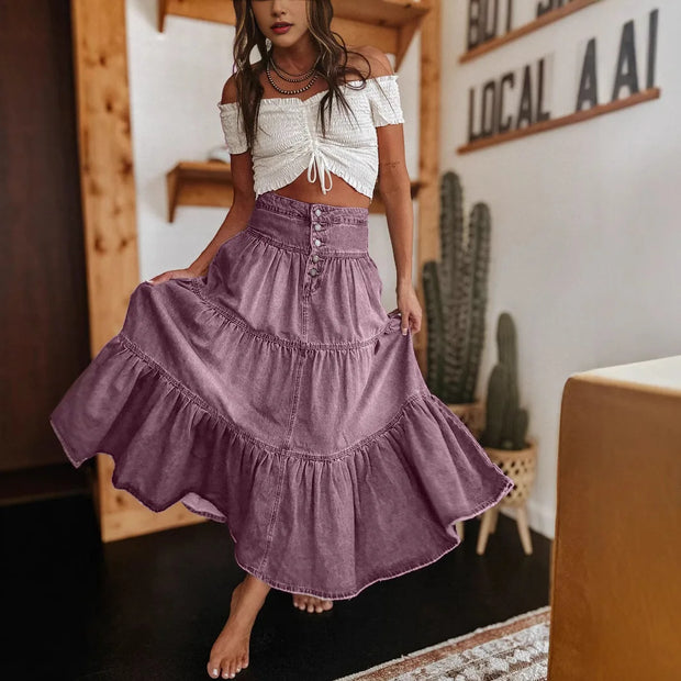 Woman wearing a white top and purple skirt in a room with wooden shelves and cacti.