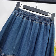 Blue denim skirt on a hanger against a white background