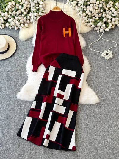 Red sweater with a letter 'H' and patterned black, white, and red pants on a gray surface with decorative elements.