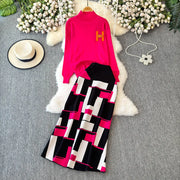 Pink top with geometric patterned pants on a gray surface with decorative elements.